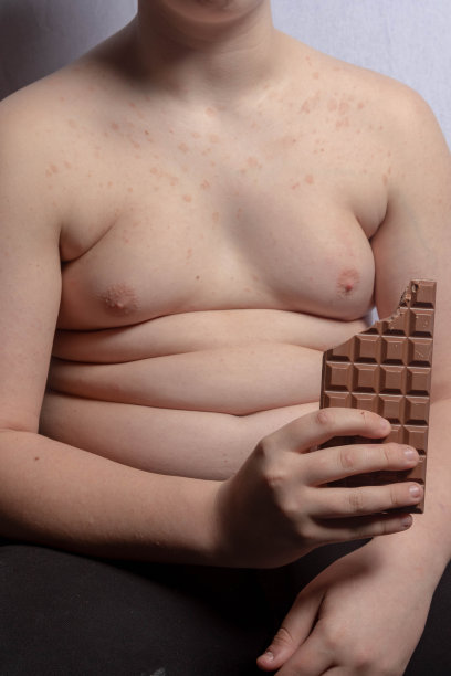 一个超重的白人少年拿着一块巧克力图片下载