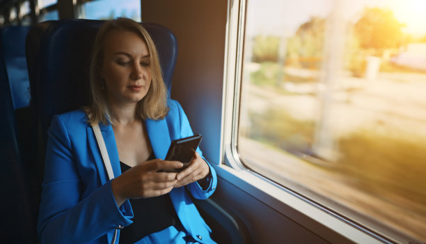 穿西装的女人乘火车旅行。图片下载