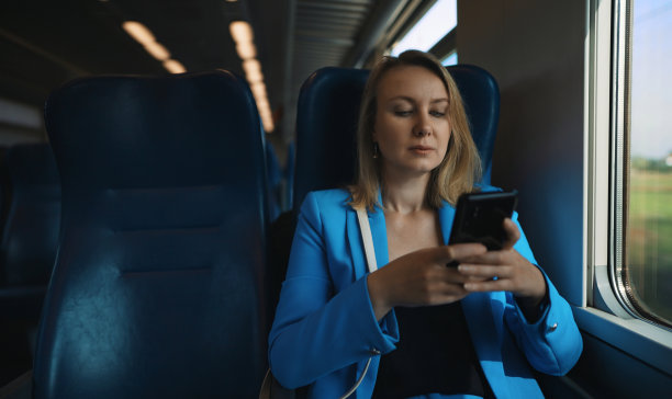 穿西装的女人乘火车旅行。图片下载