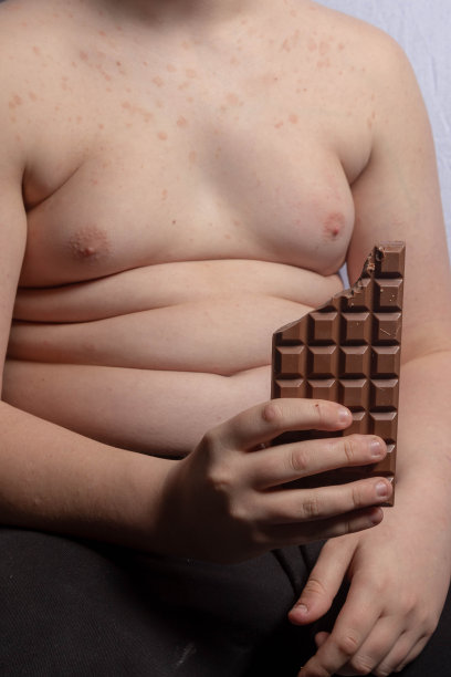 一个超重的白人少年拿着一块巧克力图片下载