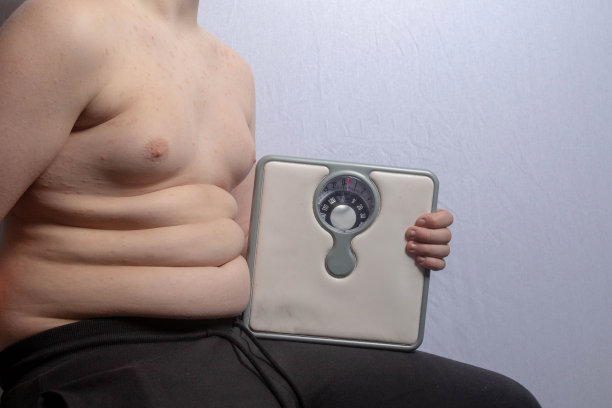 超重的白人少年，有体重秤图片下载