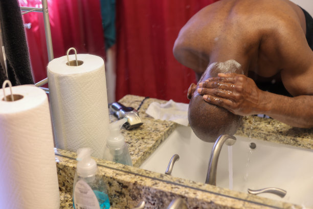 一幅黑人男子在家庭浴室里洗脸的肖像图片下载