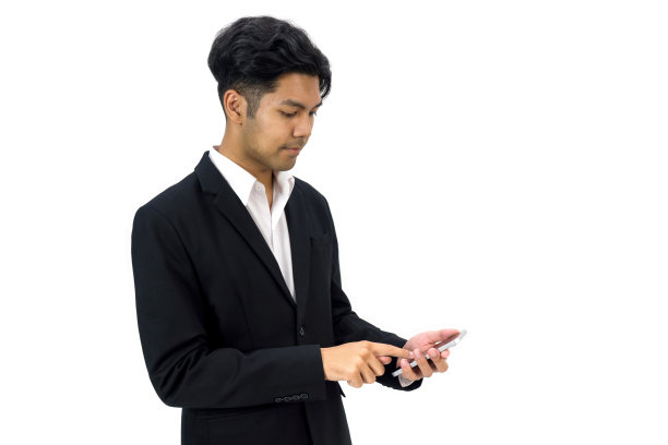 年轻的亚洲商人在白衬衫和黑西装打字短信在手机上。人像在白色背景与工作室灯光。图片下载