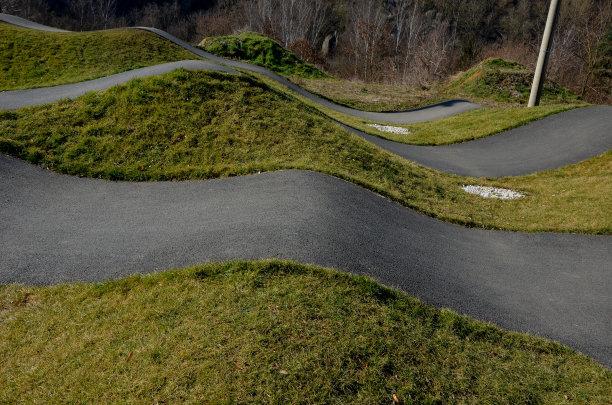 在模块化的泵道轨道上，使用泵(上下移动)代替踏板和弹跳来移动自行车、滑板、滑板和直排旱冰鞋图片下载