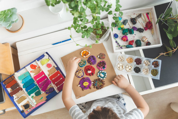 小男孩用装饰干豆元素制作橡皮泥diy人物早期发展顶视图图片下载