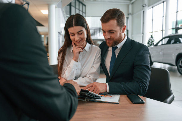 三个人在汽车陈列室里一起工作图片下载