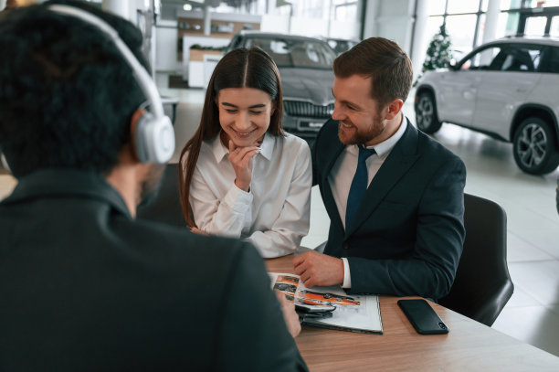一家人正在买新车。三个人在汽车陈列室里一起工作图片下载