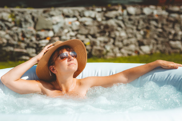 女人放松在热水漩涡浴缸。概念放松图片下载