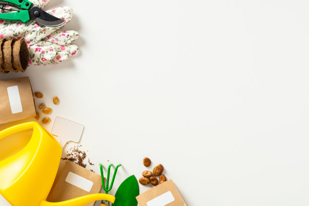 园丁店横幅设计。将浇水壶、手套、种子纸袋、耙子、铲子、修枝机平铺在白色背景上。图片下载