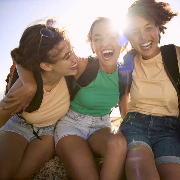 女性朋友背着背包在乡间远足休息的照片图片下载