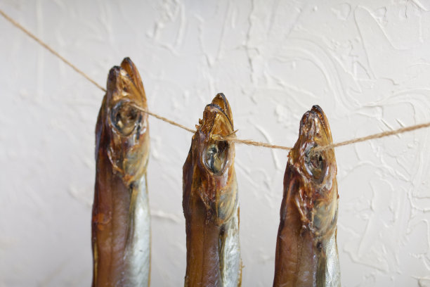 Putassu Cold抽烟。挂在绳子上。鱼用一条纸包着。用亚麻麻绳捆扎。特写镜头。图片下载