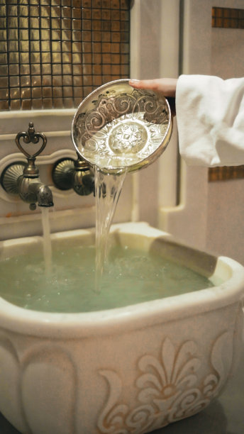 土耳其浴内部：奥斯曼风格浴池及女性用碗倒水图片下载