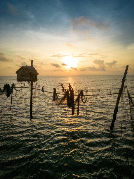 在日出时分的越南Tra Vinh省，渔民在海上拉鱼竿上的渔网的鸟瞰图，当地人称之为Day hang khoi图片下载