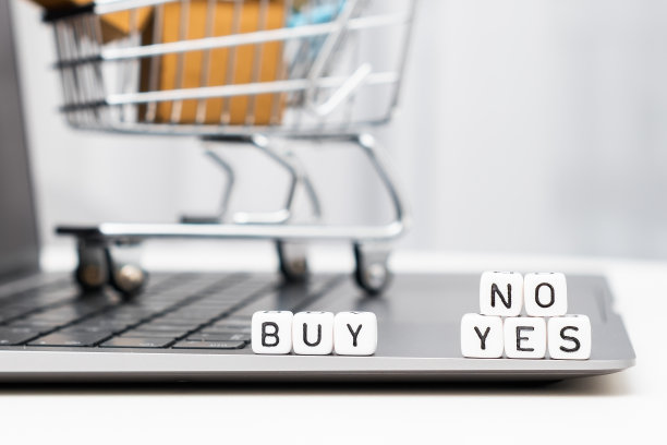 买“是”或“否”字放在笔记本电脑上的立方体上，还有一个带纸箱的玩具购物车图片下载