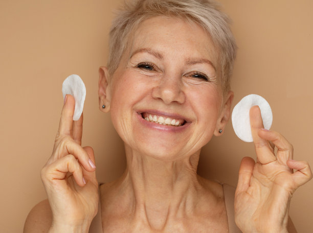 美丽的老人60岁的女人短发做她的日常工作卸妆用化妆棉图片下载