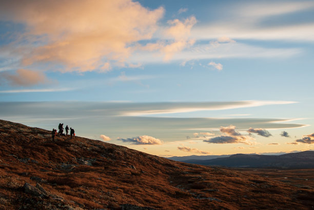 一群人在日落时分在美丽的山上徒步旅行图片下载