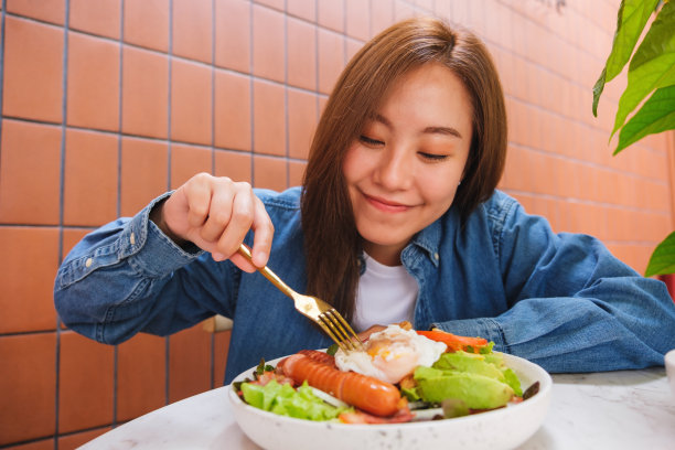一个年轻女子吃沙拉的肖像图像图片下载