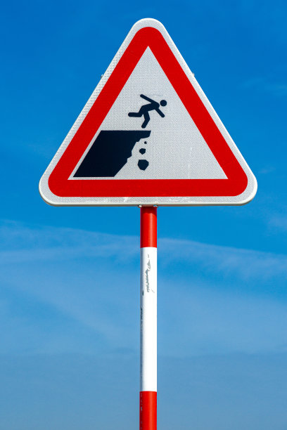 蓝天背景下坠崖危险垂直三角形路牌。图片下载