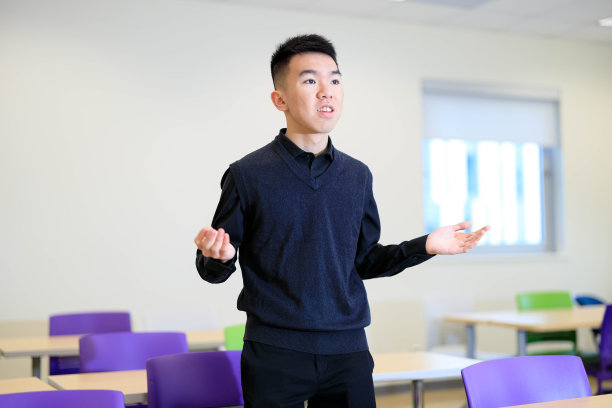 年轻的男大学生在课堂上说话和打手势图片下载