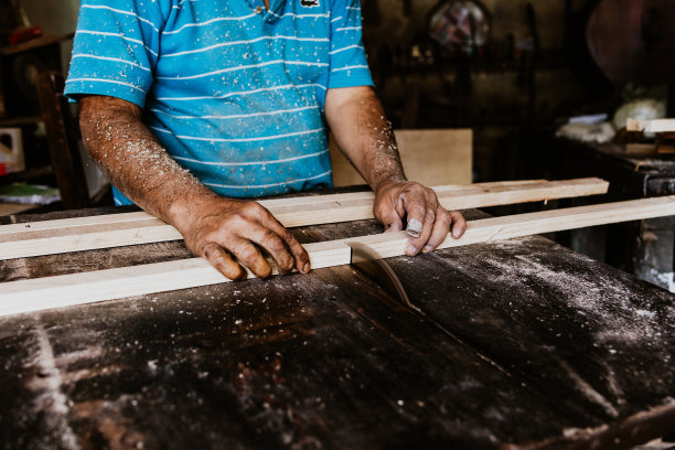 拉丁高级男子木匠使用电动圆锯切割木板，在一块木头上的车间在墨西哥拉丁美洲，西班牙人图片下载
