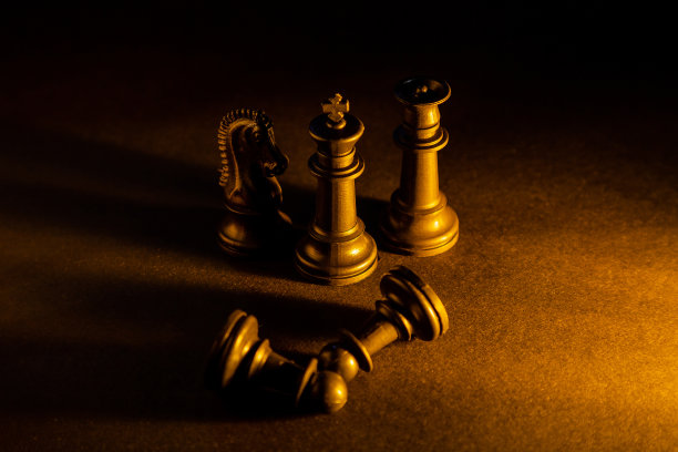 象棋棋子在黑色背景与烟，灰尘或火的效果和金色和蓝色过滤器。国际象棋战斗的概念。图片下载