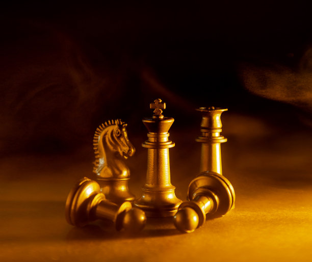 象棋棋子在黑色背景与烟，灰尘或火的效果和金色和蓝色过滤器。国际象棋战斗的概念。图片下载