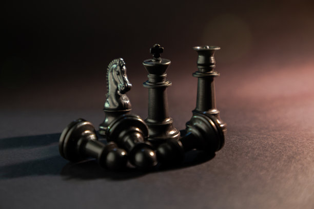 象棋棋子在黑色背景与烟，灰尘或火的效果和金色和蓝色过滤器。国际象棋战斗的概念。图片下载