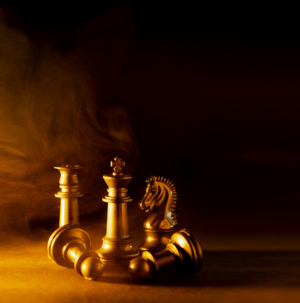 象棋棋子在黑色背景与烟，灰尘或火的效果和金色和蓝色过滤器。国际象棋战斗的概念。图片下载