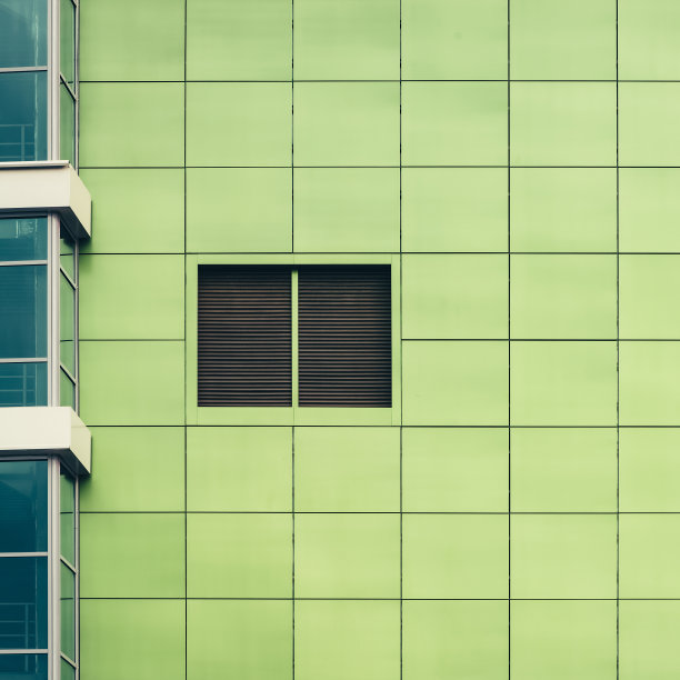 极简主义的背景与美丽光滑的绿色方形瓷砖特写。浅绿色的外墙纹理紧密相连。最小的背景与简单的绿色光滑面瓷砖的办公楼一侧。图片下载
