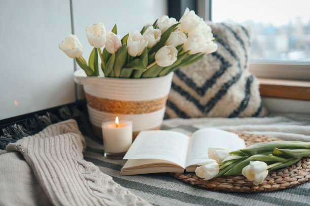 打开书，蜡烛和郁金香篮子，在家里的室内春天的舒适组成图片下载