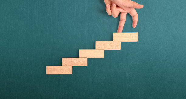 手比人走上玩具楼梯的木头图片下载