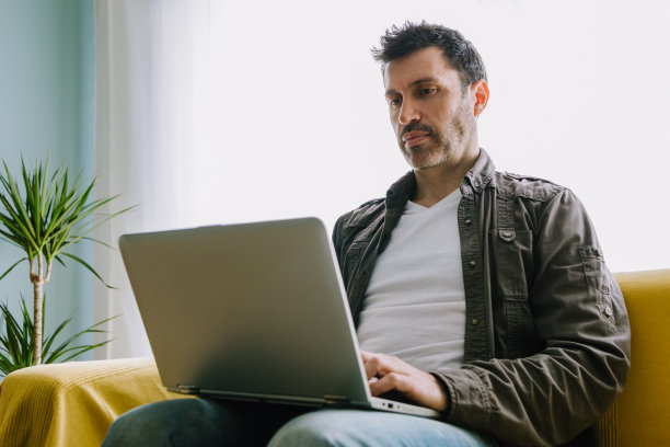 年轻人在家里的沙发上工作图片下载