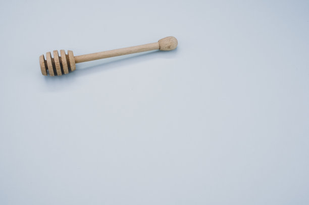 高角度拍摄的木制蜂蜜勺在灰色的表面图片下载