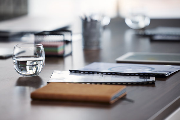 笔记本与文件，办公桌在办公室内部和放大业务表与战略报告。为创业公司、广告公司调研和公司空办公室提供调查文书工作图片下载