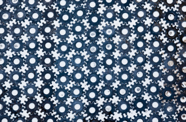 白色背景上有很多齿轮。铁齿轮整齐地堆叠在白色上。图片下载