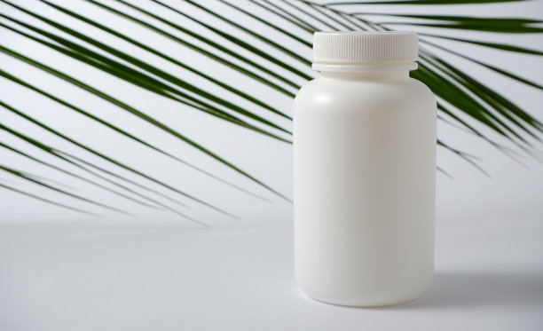 模型。白色塑料瓶，白色背景，绿色棕榈叶，装维生素，化妆品，保健品。美容医疗美容产品图片下载