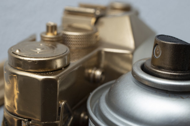 金色的喷雾罐旁边是金色的老式相机图片下载