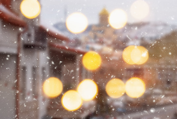 第比利斯市美丽的冬季模糊背景与飘落的雪和散景灯图片下载