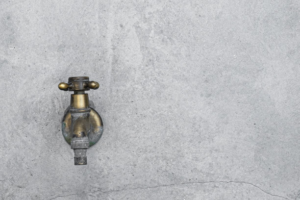 混凝土墙上的黄铜水龙头图片下载