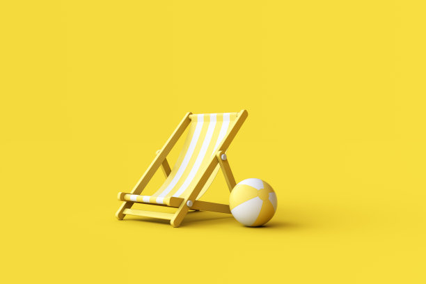 黄色背景的条纹甲板椅和沙滩球。图片下载