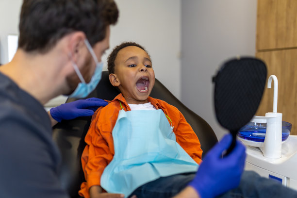 黑皮肤的男孩在牙医办公室看着镜子图片下载