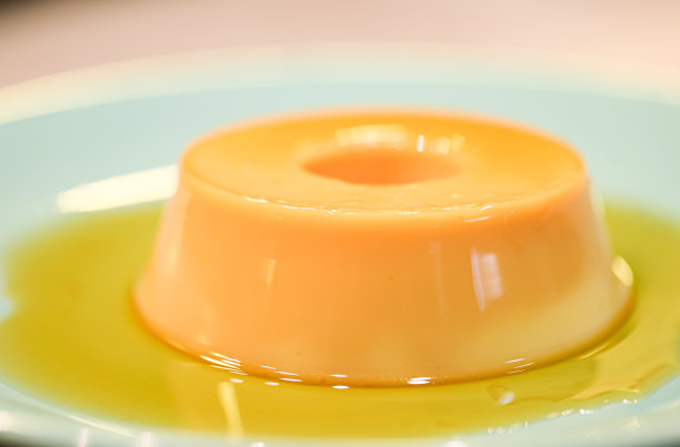 小布丁放在绿色甜点盘中的小奶油布丁巴西甜点，葡萄牙语叫Pudim de leite condenado。特写照片。图片下载
