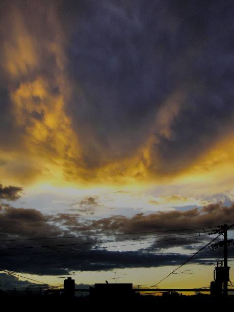 城市剪影在戏剧性的天空下，云层被暮色照亮。图片下载