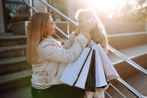 时尚的妈妈和小女孩购物袋附近的商场。图片下载