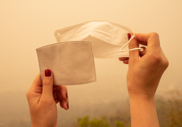 为了防止严重的空气污染，有人拿着带过滤器的口罩。图片下载