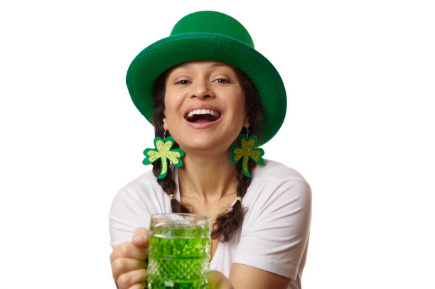 性感女服务员在绿色妖精帽子和三叶草叶子耳环，带来一杯绿色啤酒在圣帕特里克的酒吧派对图片下载