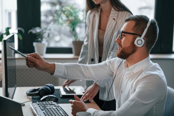 分析屏幕上的信息。两名员工在现代化的办公室里一起工作图片下载