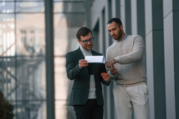 阅读文档。身着正装的商人和一个黑人在城市的户外图片下载