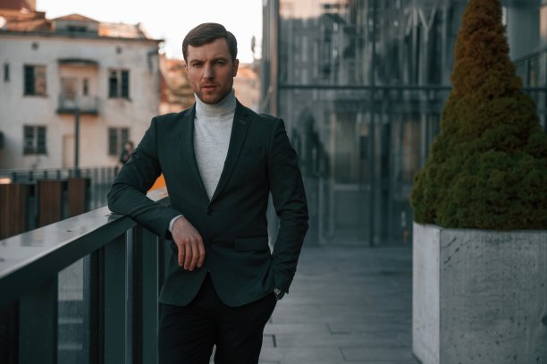 一个穿着正装的英俊男子在商务大楼附近的室外图片下载
