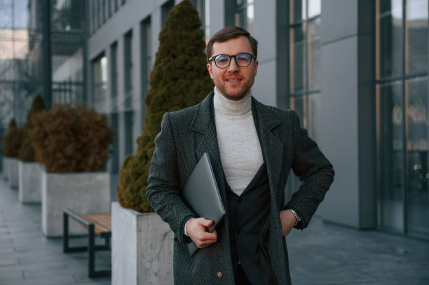 一个穿着正装的英俊男子在商务大楼附近的室外图片下载